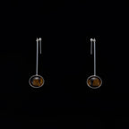 Minimalist vertical drop earrings in 925 sterling silver and natural Tiger Eye. Featuring a unique composite sphere and muted lustre finish. Architectural jewelry by Saël.