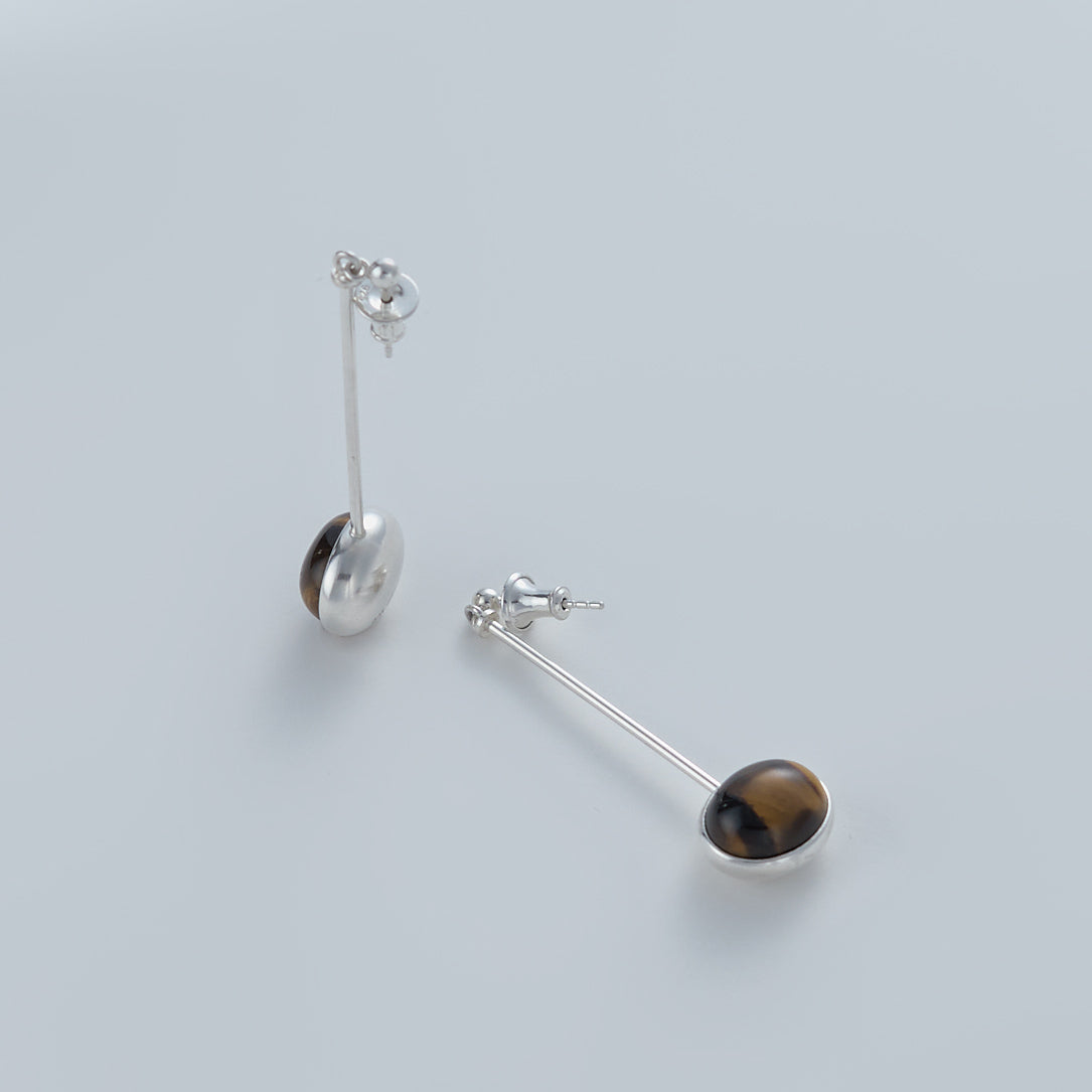 Minimalist vertical drop earrings in 925 sterling silver and natural Tiger Eye. Featuring a unique composite sphere and muted lustre finish. Architectural jewelry by Saël.