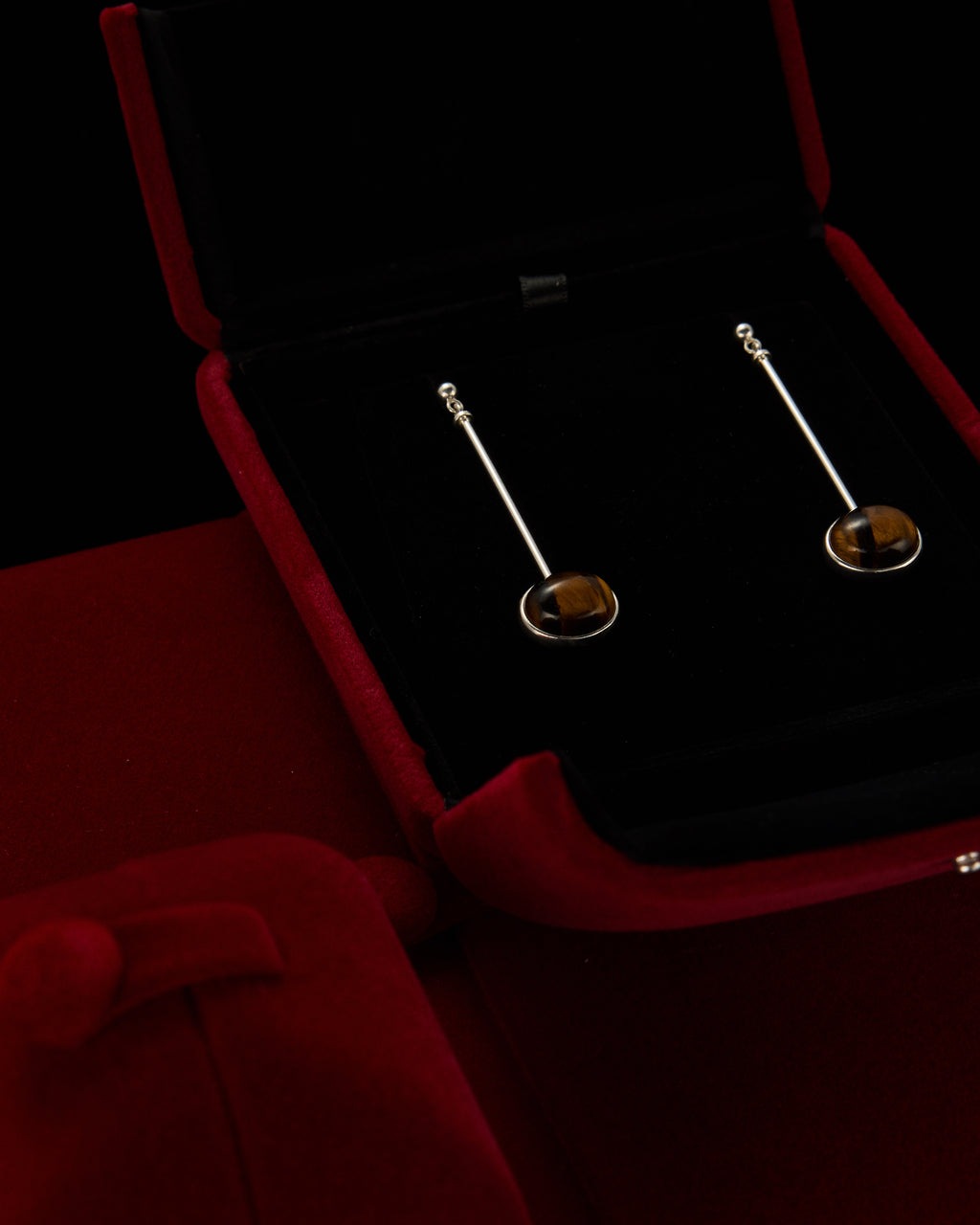 Minimalist vertical drop earrings in 925 sterling silver and natural Tiger Eye. Featuring a unique composite sphere and muted lustre finish. Architectural jewelry by Saël.